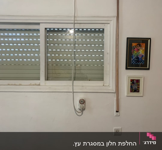 חלון הזזה ומזגן עילי עם כבל חשמל משתלשל
